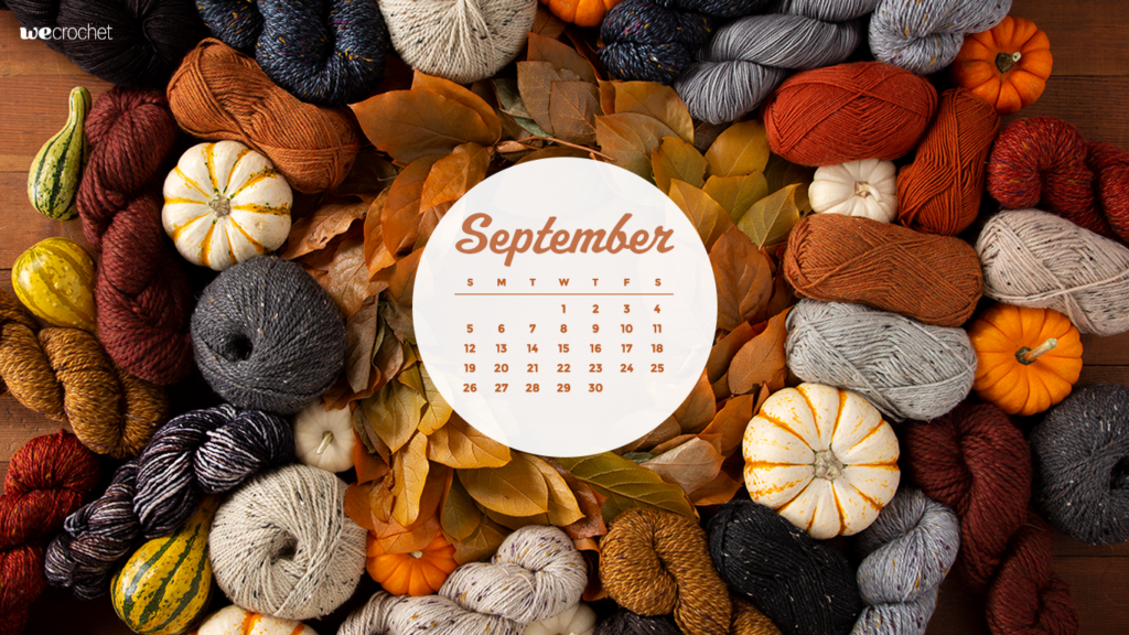 A large pile of various yarn in fall colors (rust, pumpkin, gray, maroon), along with assorted decorative pumpkins. A white circle in the middle with the Sept 2021 calendar inside it.