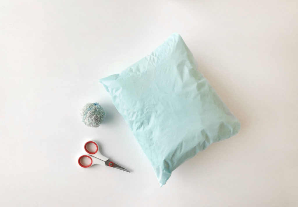 Supplies needed: A package, a ball of yarn, and scissors
