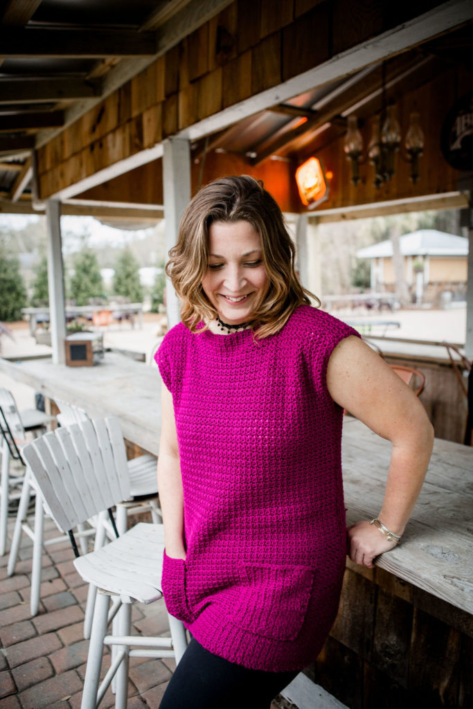Tobago minidress by Crochet Foundry: A woman wears a fuchsia tunic minidress with short sleeves and patch pockets on the hips.